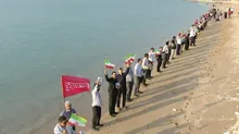زنجیره انسانی استادان و نخبگان دانشگاهی در ساحل جزیره هرمز؛ تأکید بر دفاع از جزایر و مرزهای جنوبی کشور